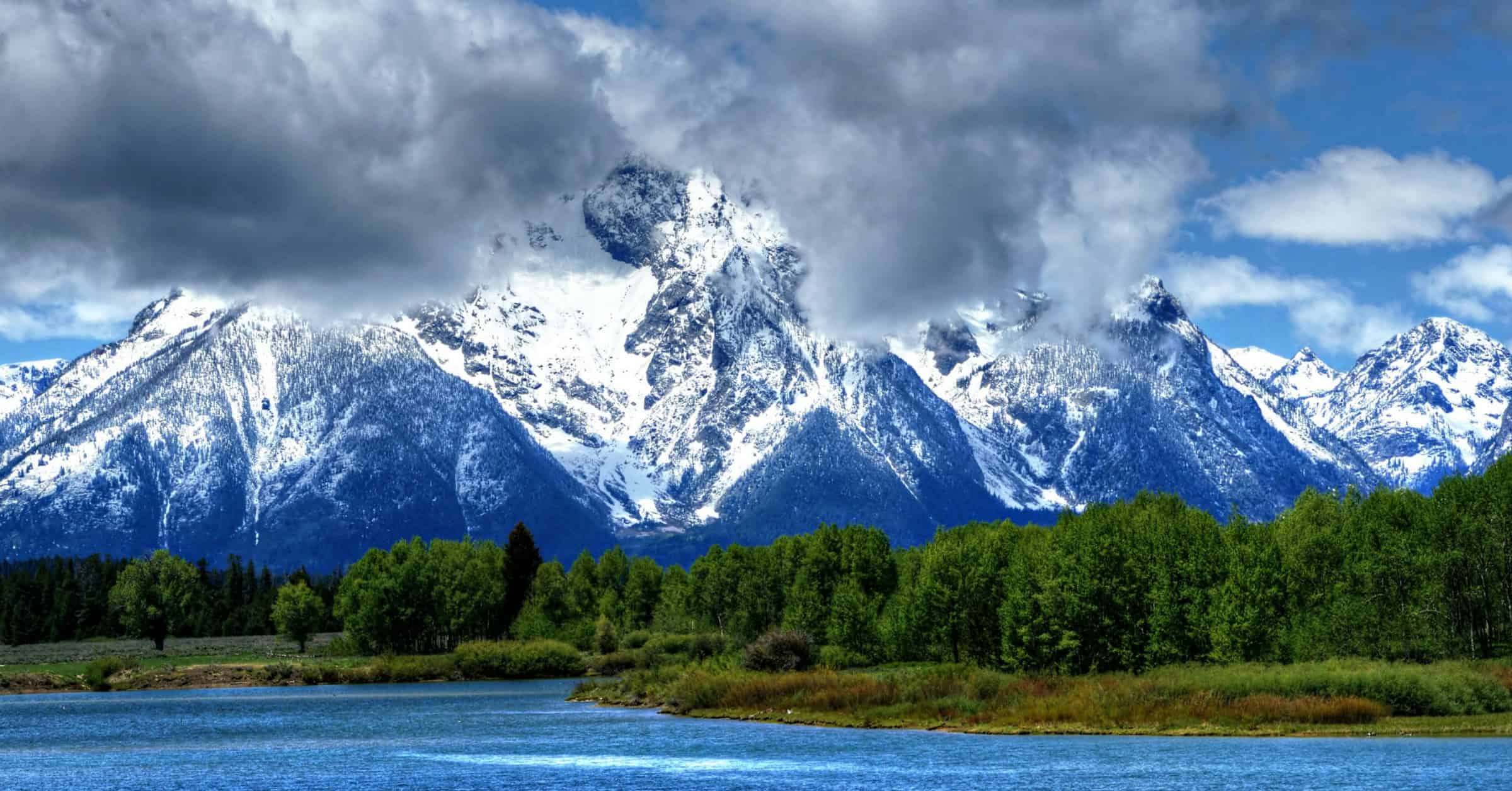 Snow-capped peaks of the Grand Tetons and Mount Moran reflected in a calm lake, Wyoming